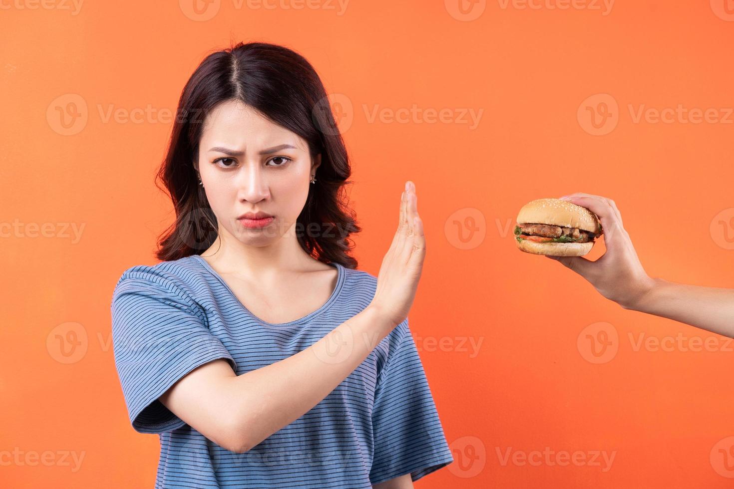 jovem asiática desistindo do hábito de comer hambúrgueres foto