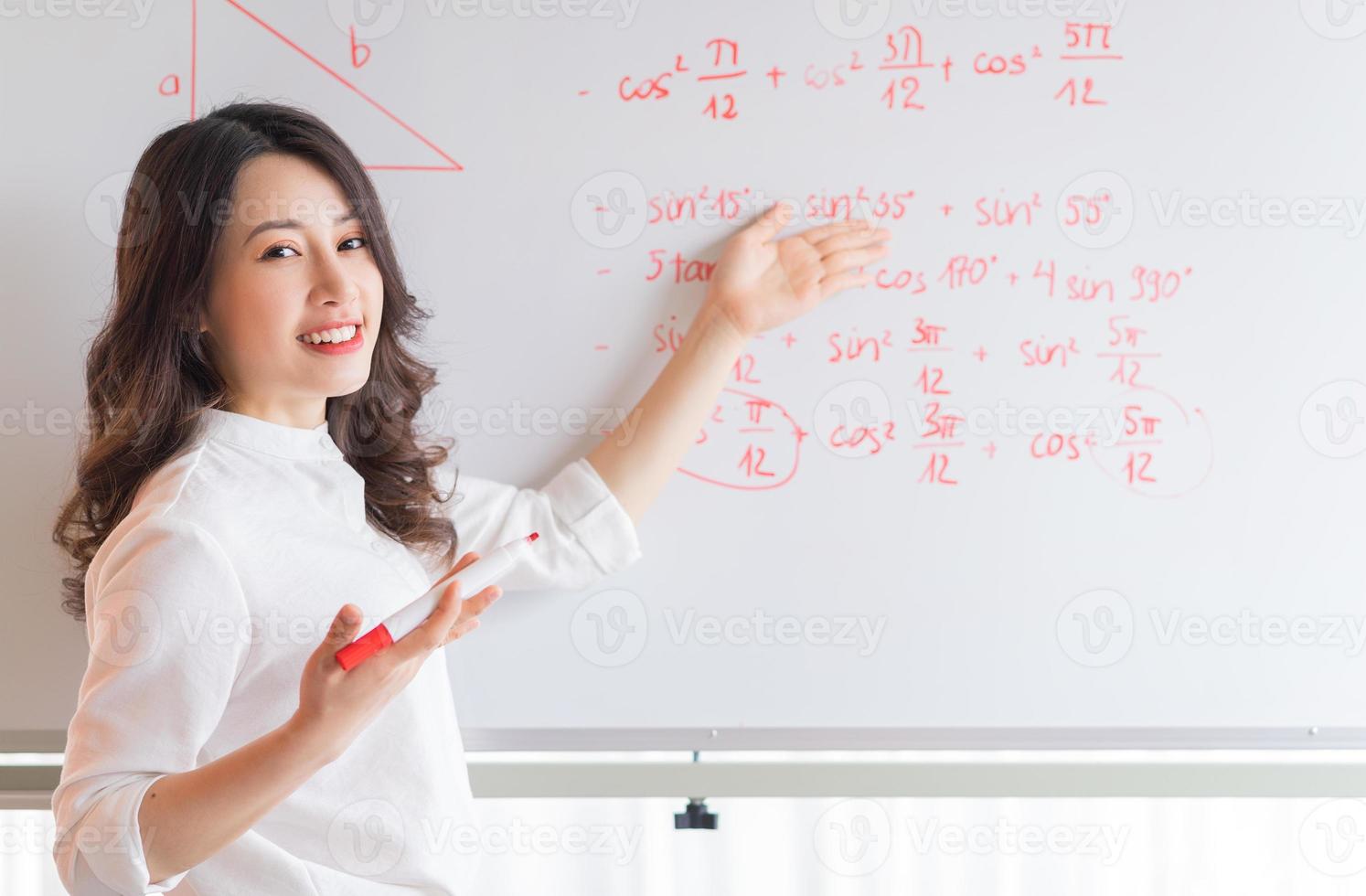 a professora asiática está reescrevendo a palestra no quadro foto