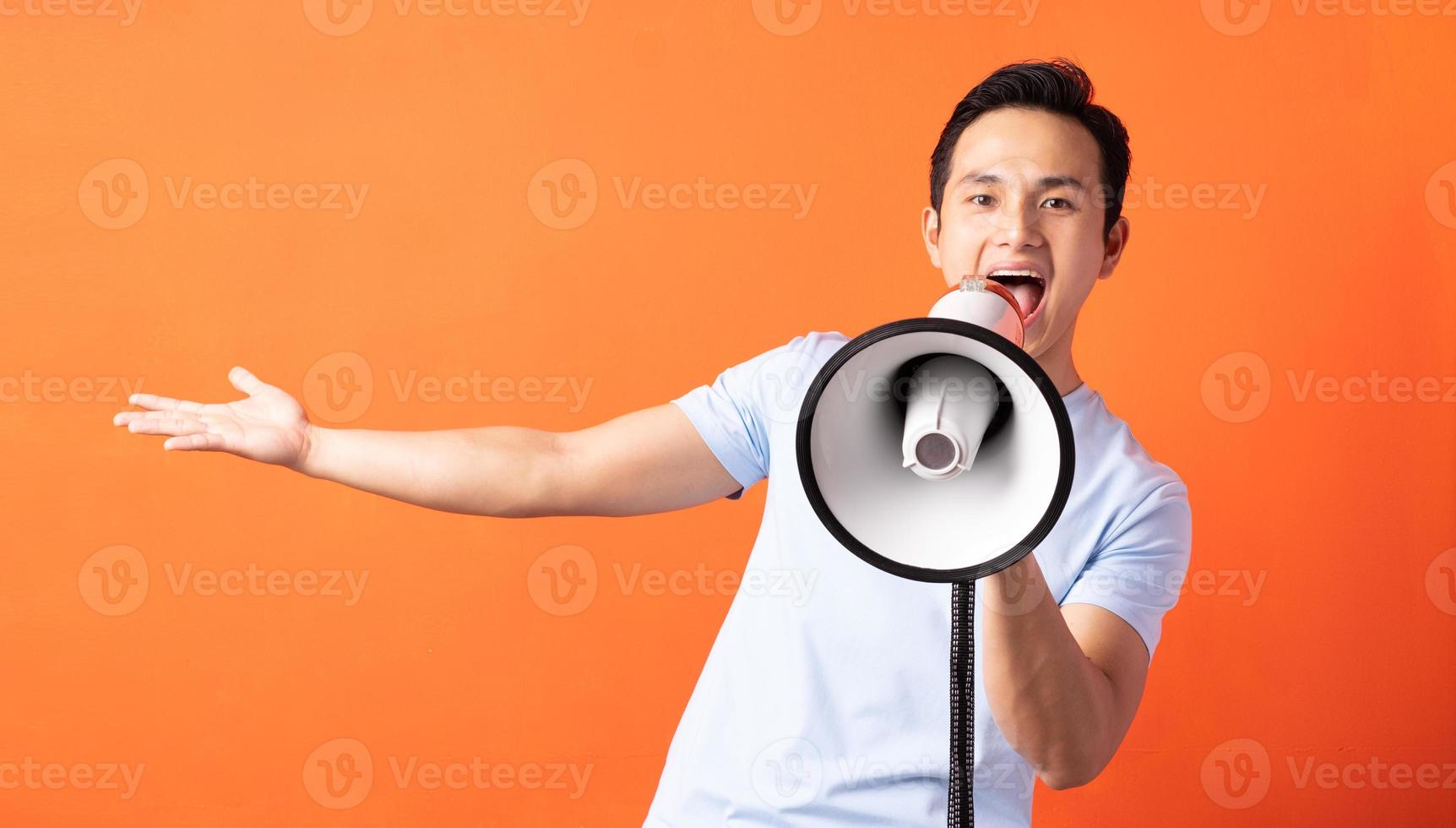 homem asiático segurando um megafone e gritando foto