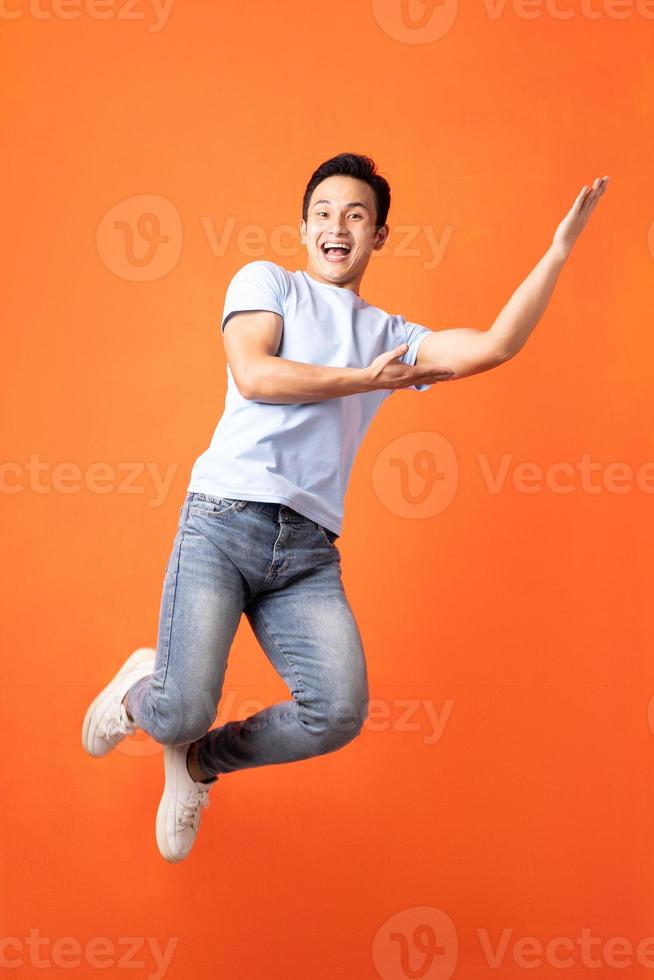 homem asiático pulando e mostrando foto