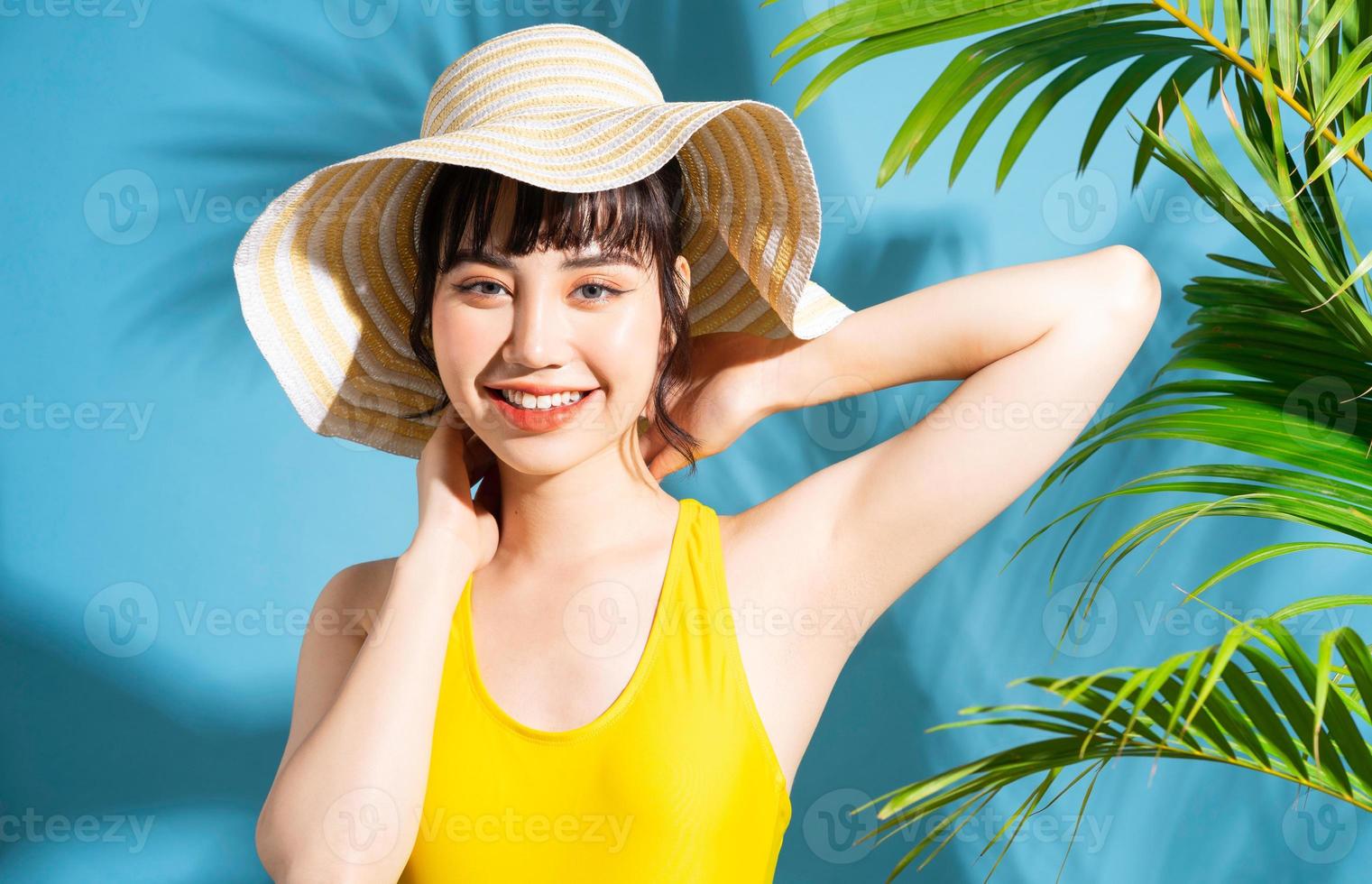 linda mulher asiática vestindo macacão amarelo sobre fundo azul e, conceito de verão foto