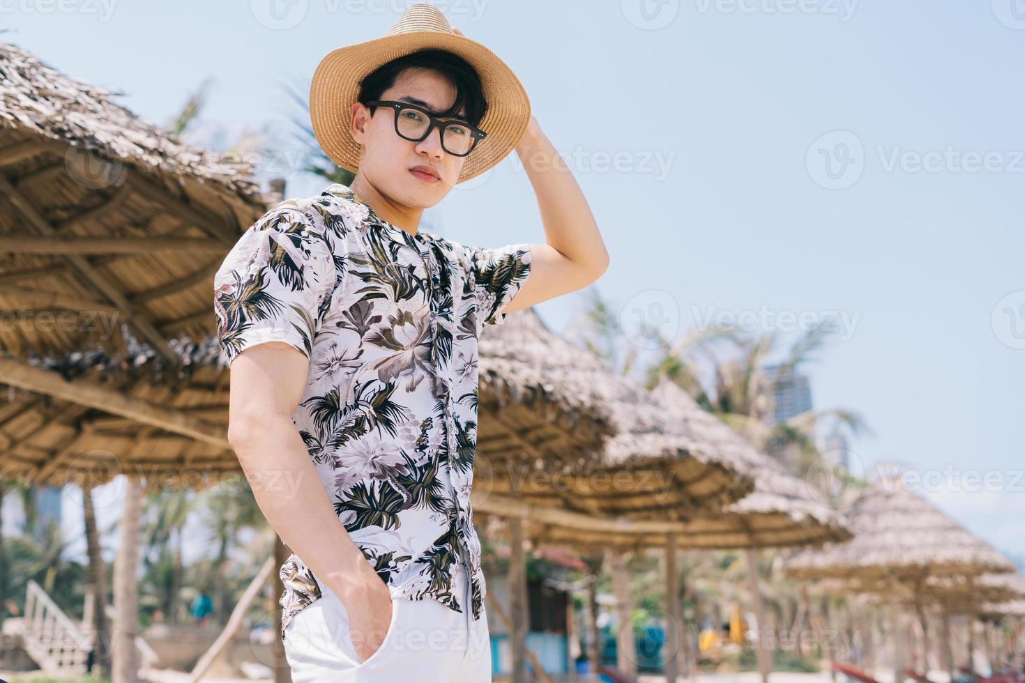 jovem asiático caminhando na praia foto