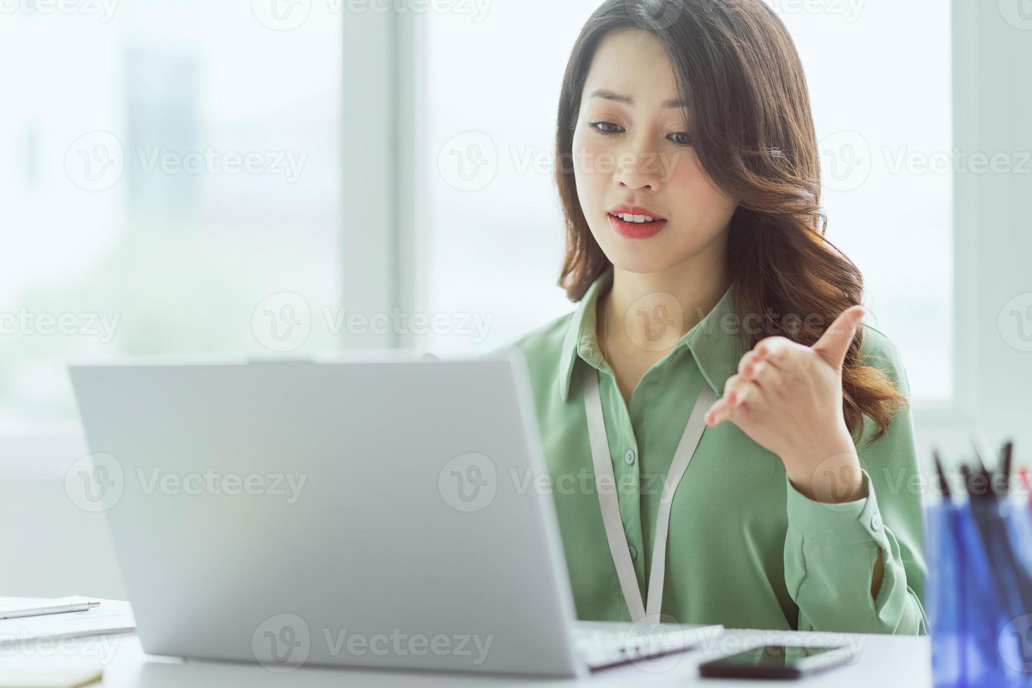 linda empresária asiática sentada trabalhando no escritório foto