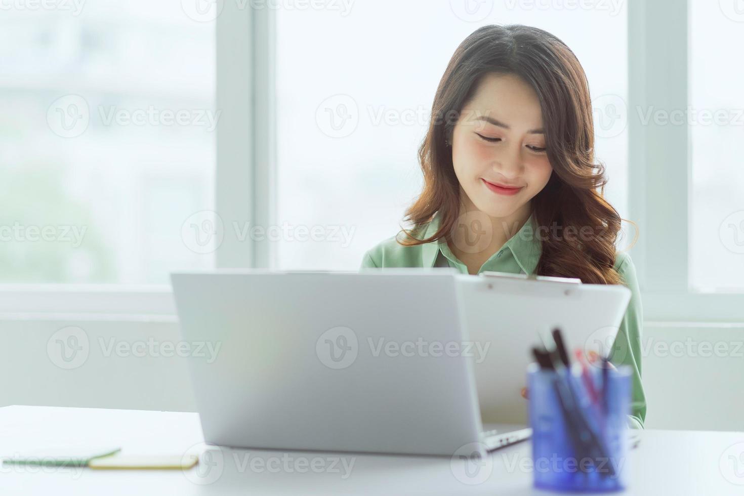 linda empresária asiática sentada trabalhando no escritório foto