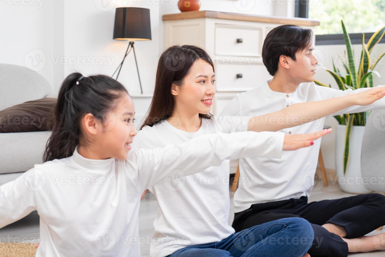 jovem família asiática fazendo exercícios juntos em casa foto