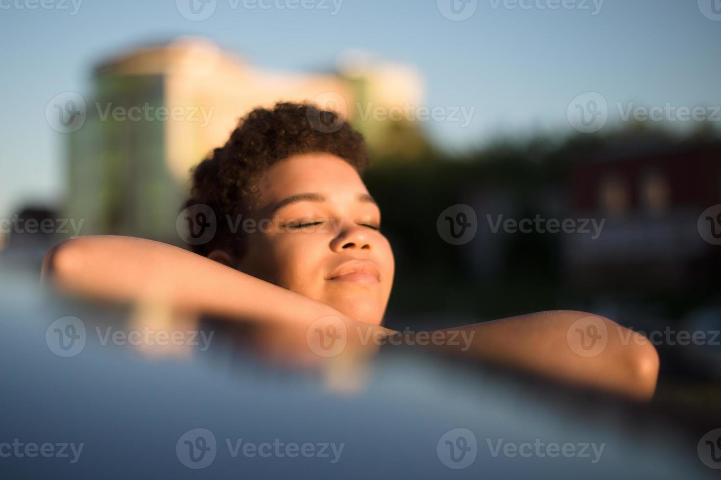 linda mulher afro-americana com cabelo curto perto do carro, estilo de vida foto