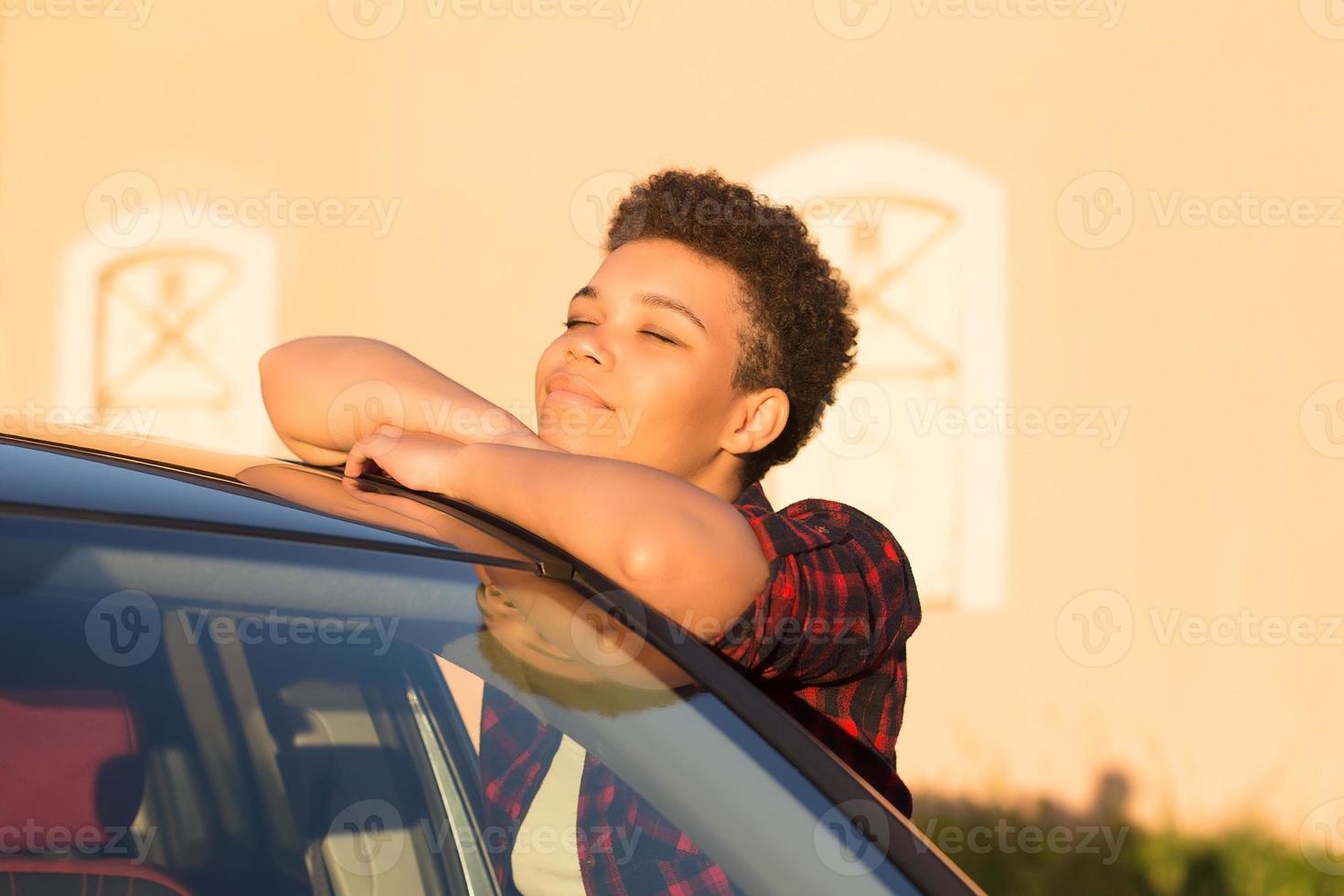 linda mulher afro-americana com cabelo curto perto do carro, estilo de vida foto