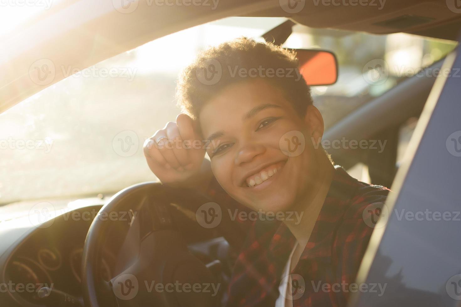 linda mulher afro-americana com cabelo curto no carro, estilo de vida foto