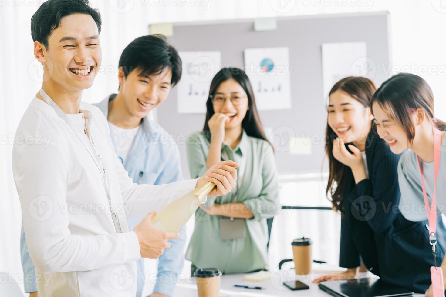 empresário asiático está abrindo champanhe para celebrar o ano novo com os membros do grupo empresarial foto