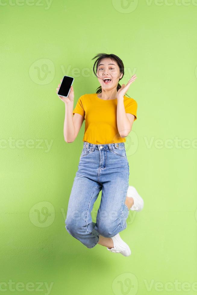 retrato de corpo inteiro de jovem asiática sobre fundo verde foto