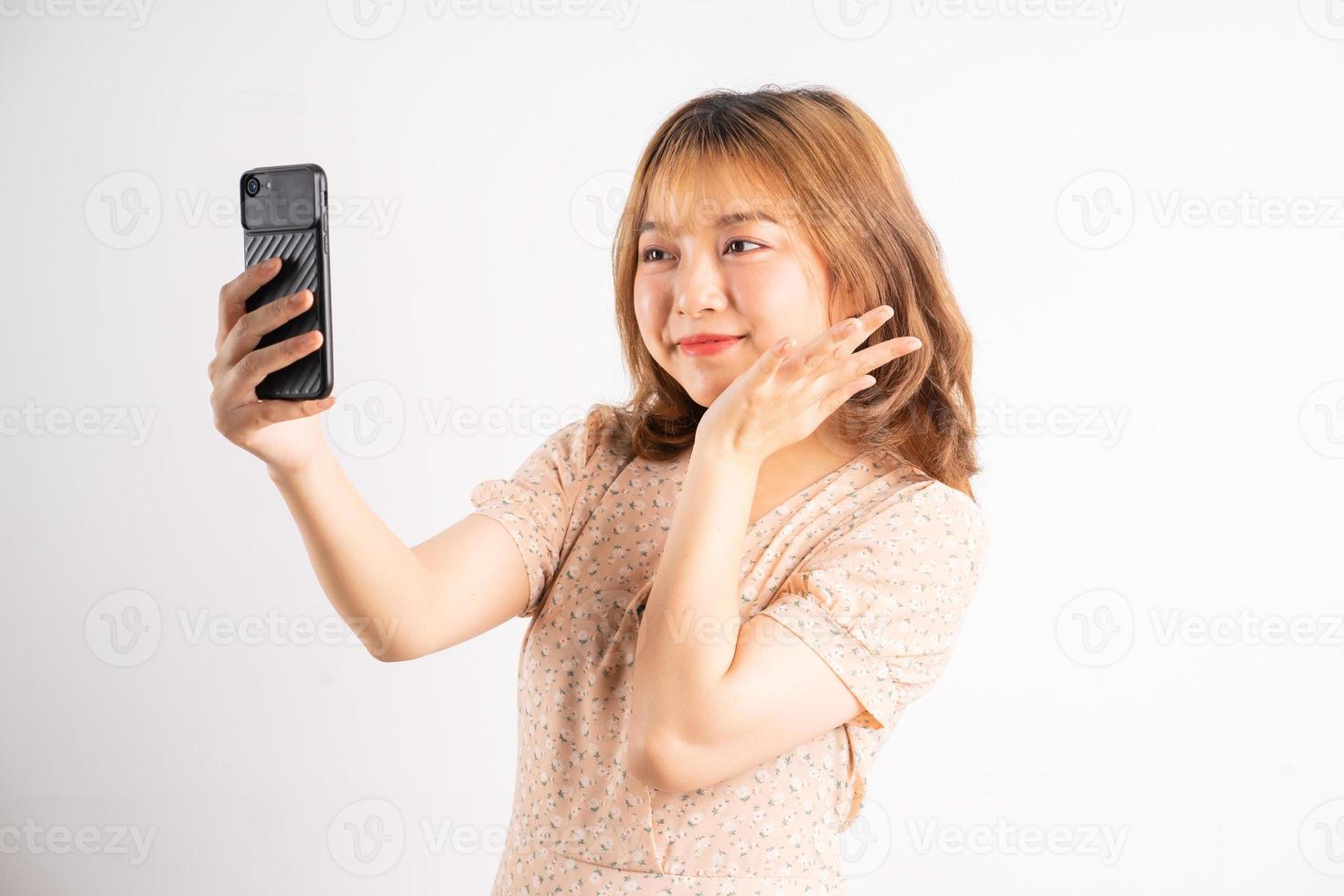 jovem asiática segurando o telefone com expressões, gestos no fundo foto