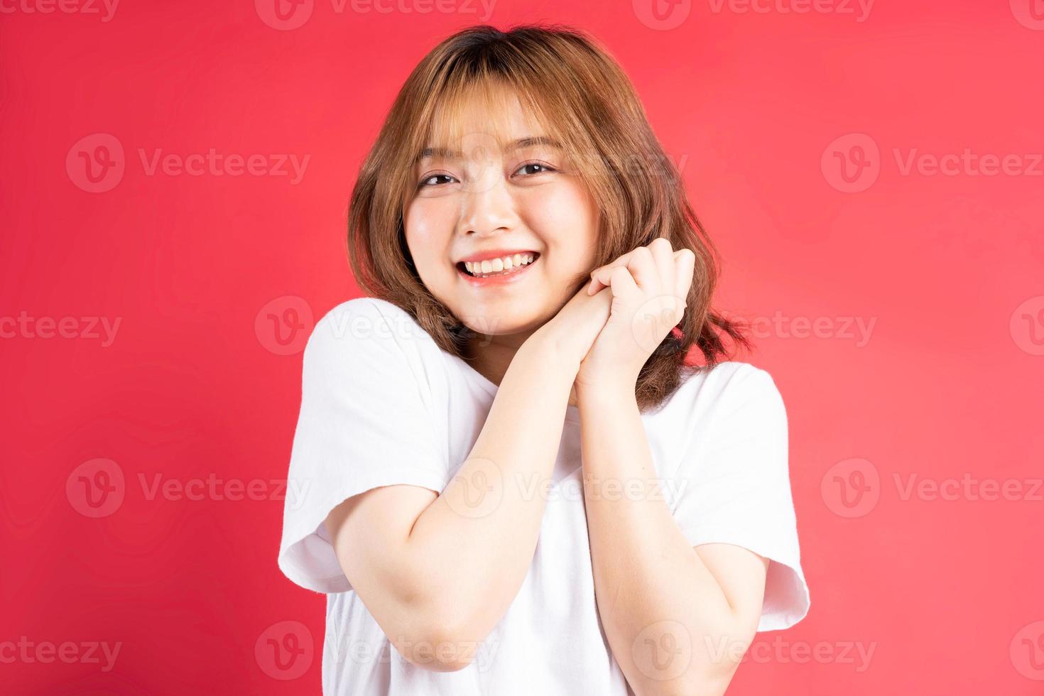 jovem garota asiática com gestos e expressões alegres no fundo foto