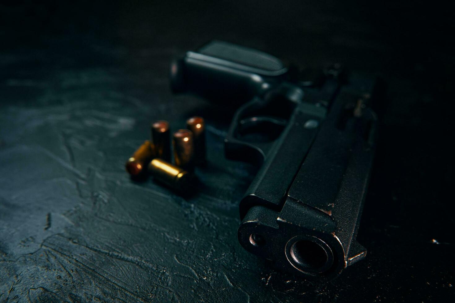 arma preta e balas na mesa. foto