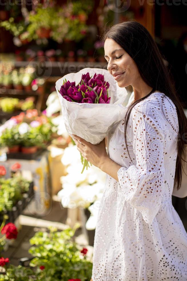 jovem comprando flores no mercado de flores foto