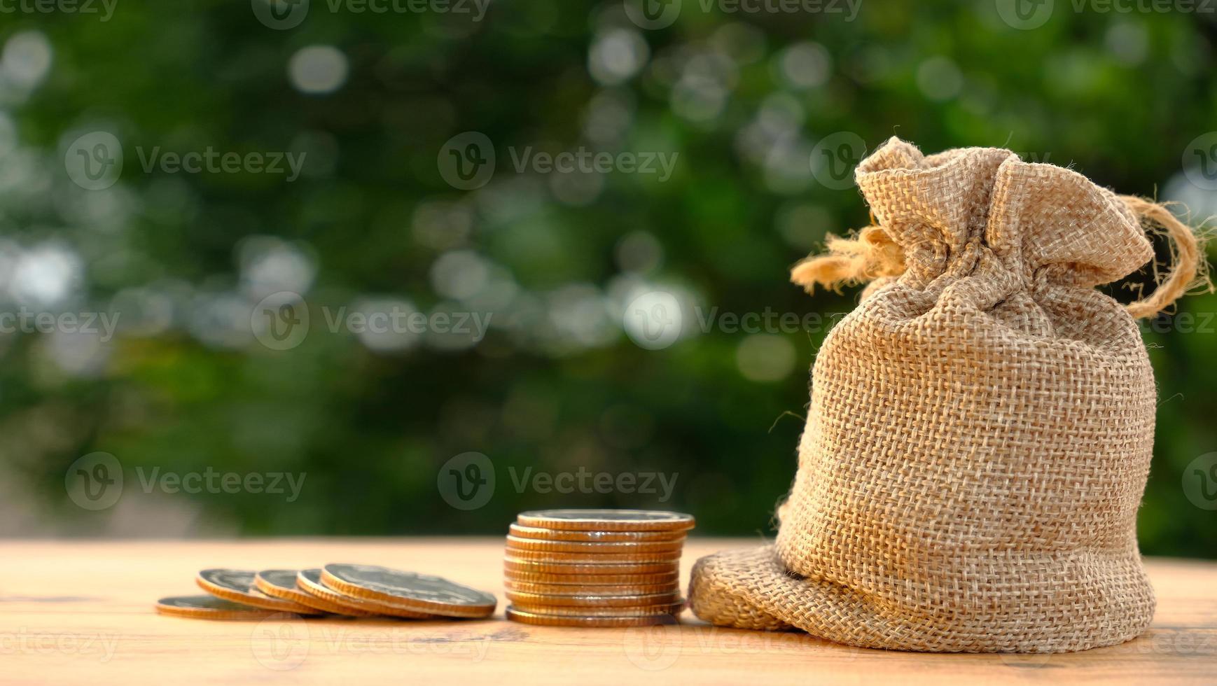 pilha de moedas no fundo da mesa e economizando dinheiro e conceito de crescimento de negócios, finanças e investimento foto