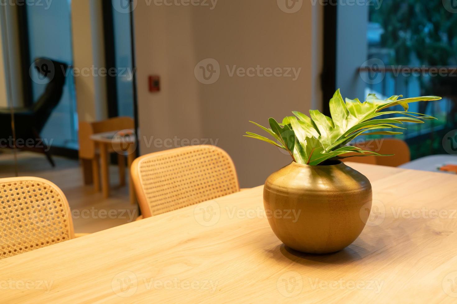 decoração de folhas em vasos na mesa de jantar de madeira foto