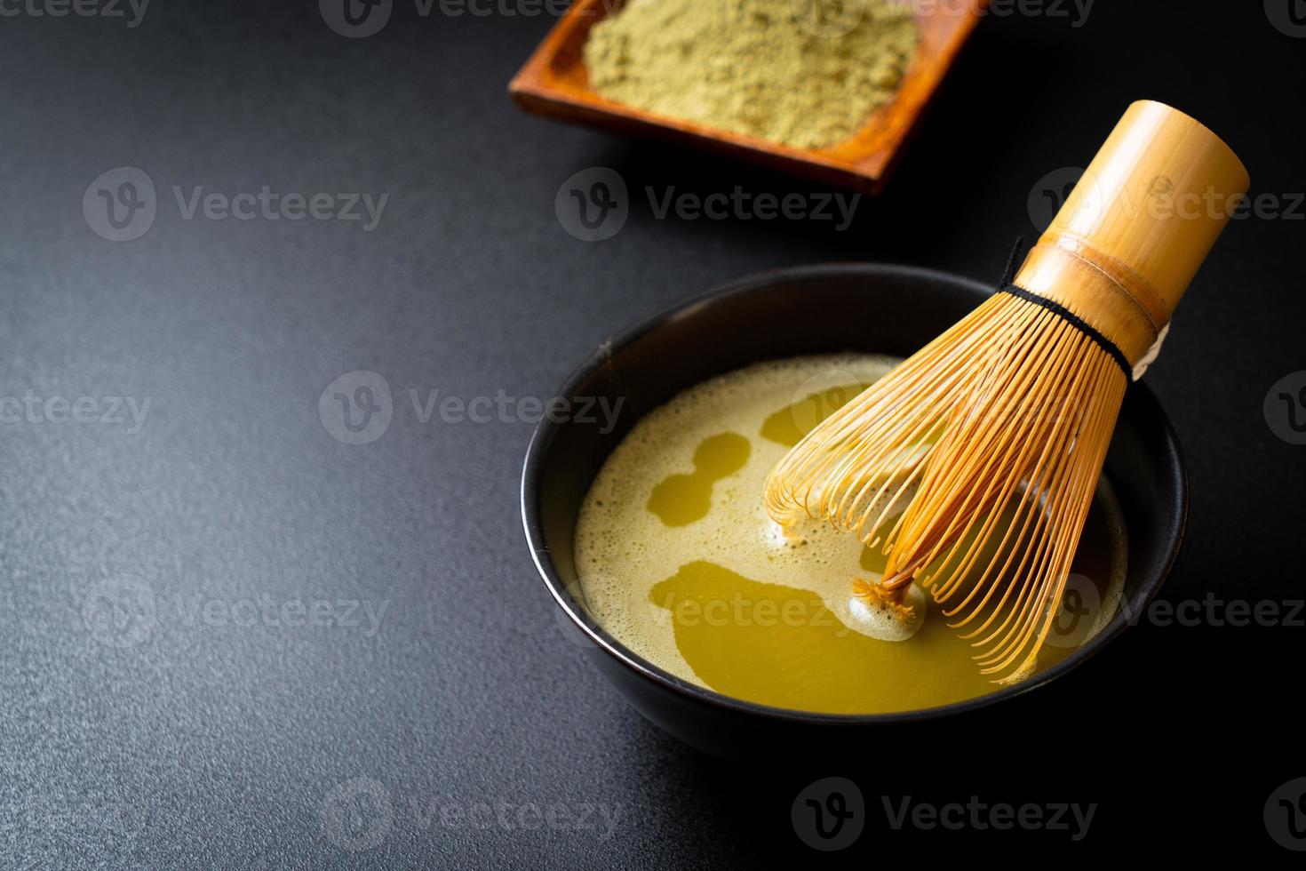 xícara de chá verde matcha quente com pó de chá verde e batedor de bambu foto