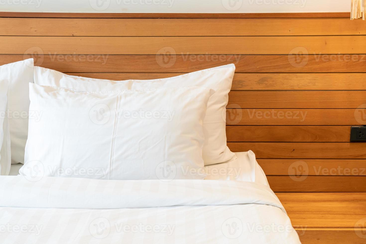 decoração de travesseiro branco na cama no interior do quarto foto