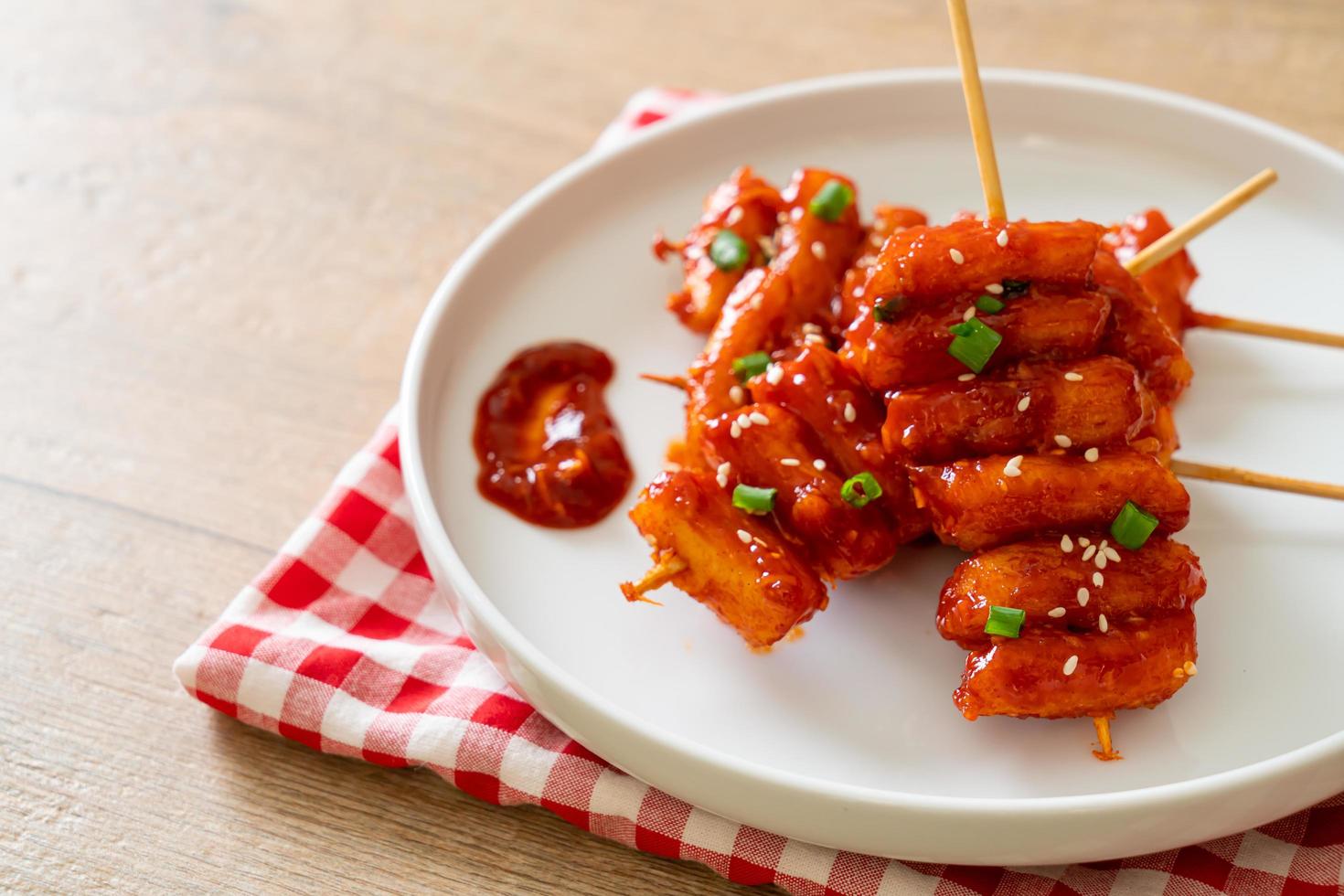 bolo de arroz coreano frito, ou tteokbokki, espetado com molho picante - comida coreana foto