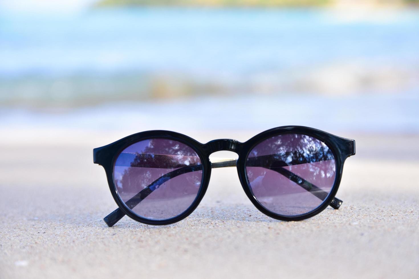 o vidro solar está no fundo da vista do mar da praia, conceito de férias de verão foto