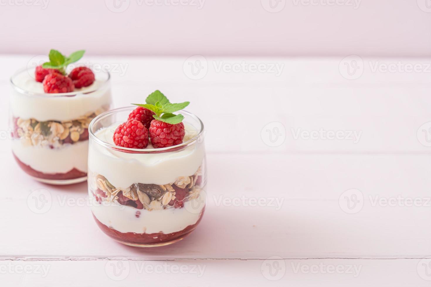 Framboesa fresca e iogurte com granola - estilo de comida saudável foto