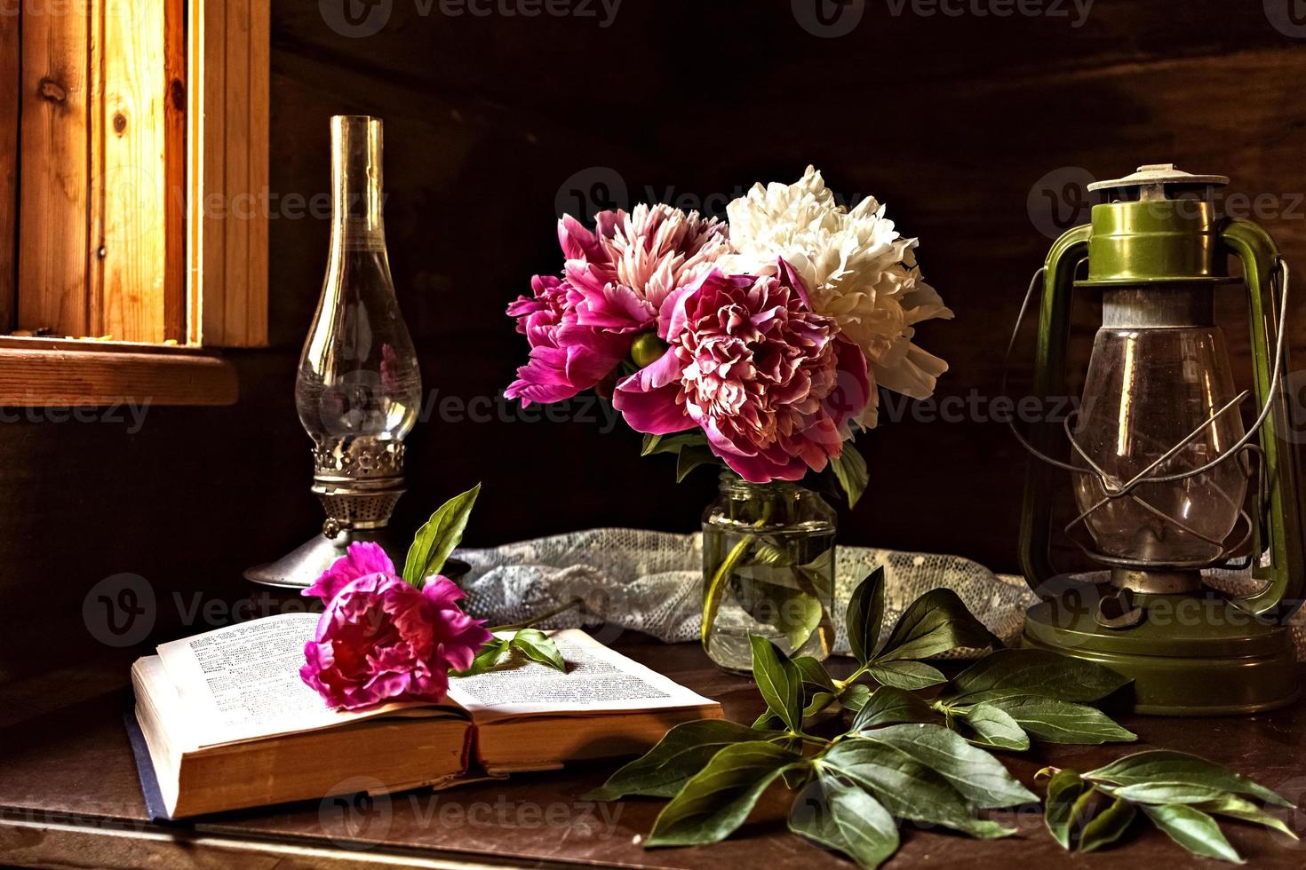 natureza morta de itens vintage e um buquê de peônias em uma mesa perto da janela em uma antiga casa de aldeia. foto