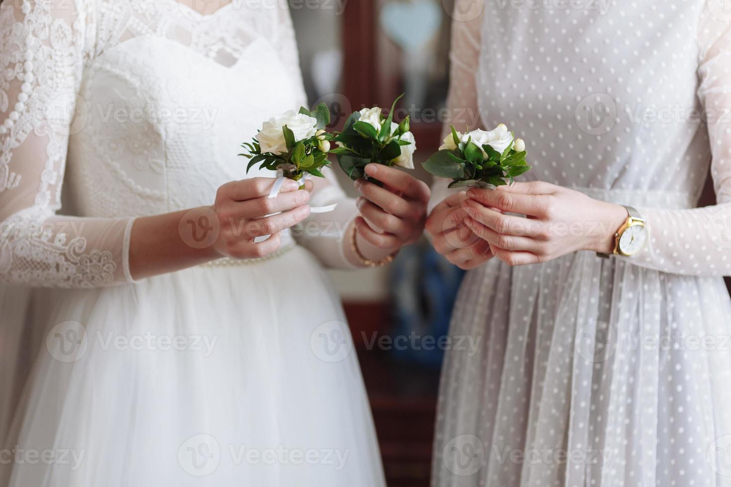 lindo florete de casamento com flores brancas e verdes nas mãos da noiva e namoradas em vestidos brancos foto