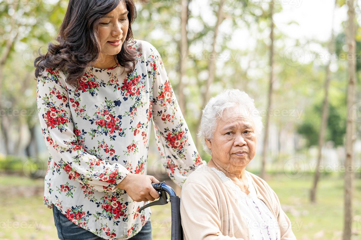 paciente asiático sênior ou idosa senhora idosa com cuidado, ajuda e suporte na cadeira de rodas no parque em férias, conceito médico forte saudável. foto
