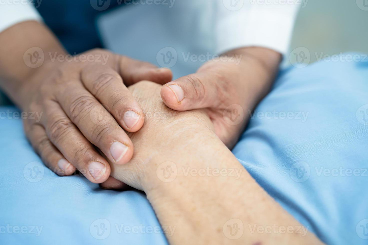 médico segurando mãos comoventes paciente idosa asiática sênior ou idosa com amor, carinho, ajuda, incentivo e empatia na enfermaria do hospital de enfermagem, conceito médico forte e saudável foto