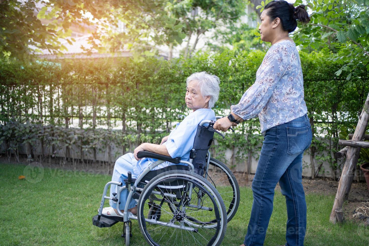 médico, ajuda e cuidado paciente asiático sênior ou idosa senhora sentada na cadeira de rodas no parque na enfermaria do hospital, conceito médico forte e saudável. foto