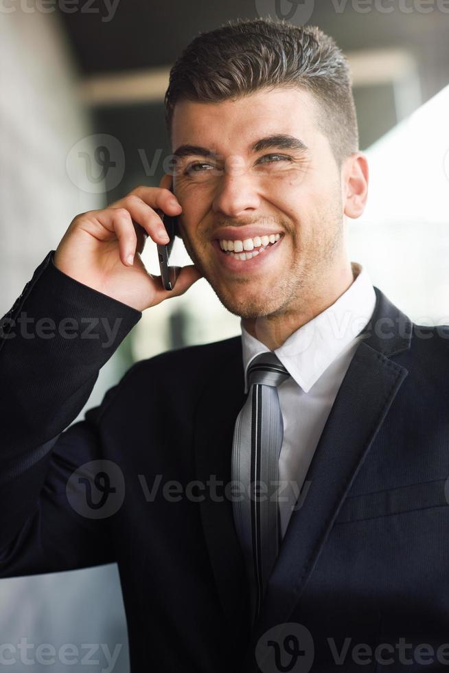 jovem empresário ao telefone em um prédio de escritórios foto