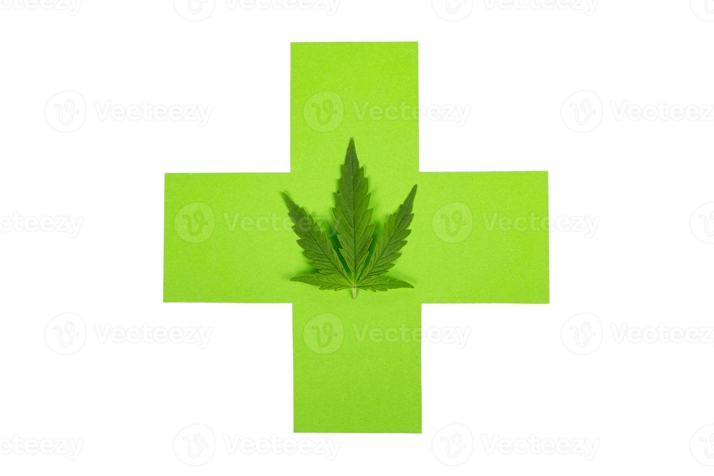 maconha medicinal, cruz verde e folha de cannabis isolada no fundo branco foto