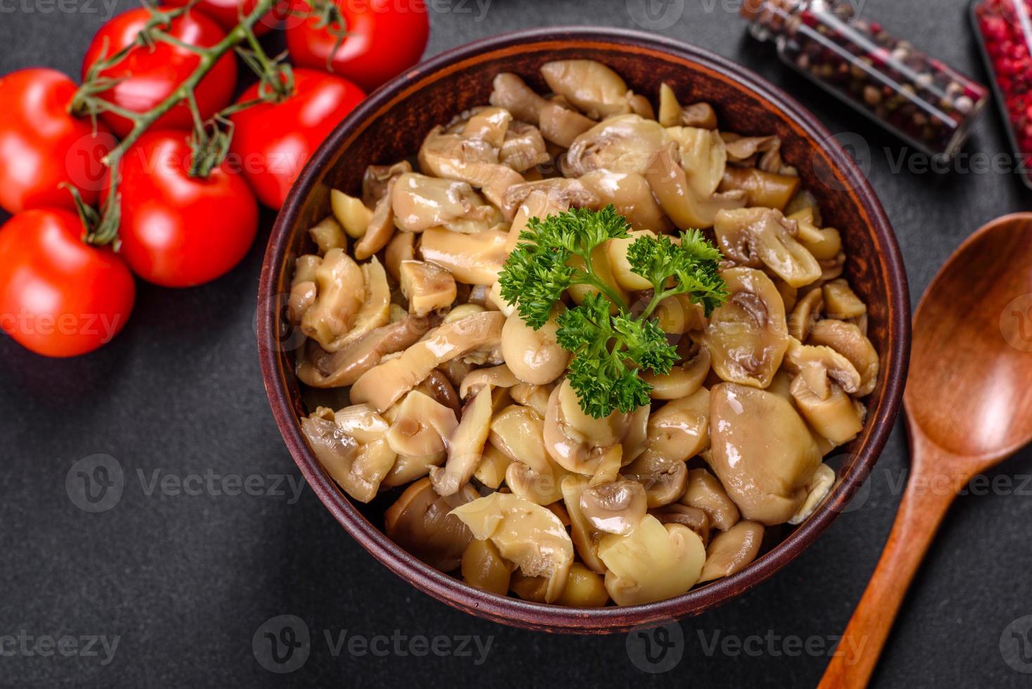 Cogumelos frescos deliciosos picantes em conserva com especiarias e ervas em pratos de cerâmica foto