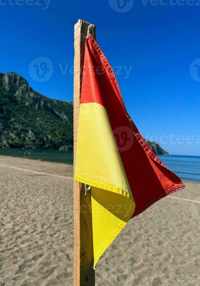 de praia bandeira segurança areia viagem Vejo lado oceano bandeira vermelho amarelo bandeira onda ensolarado foto