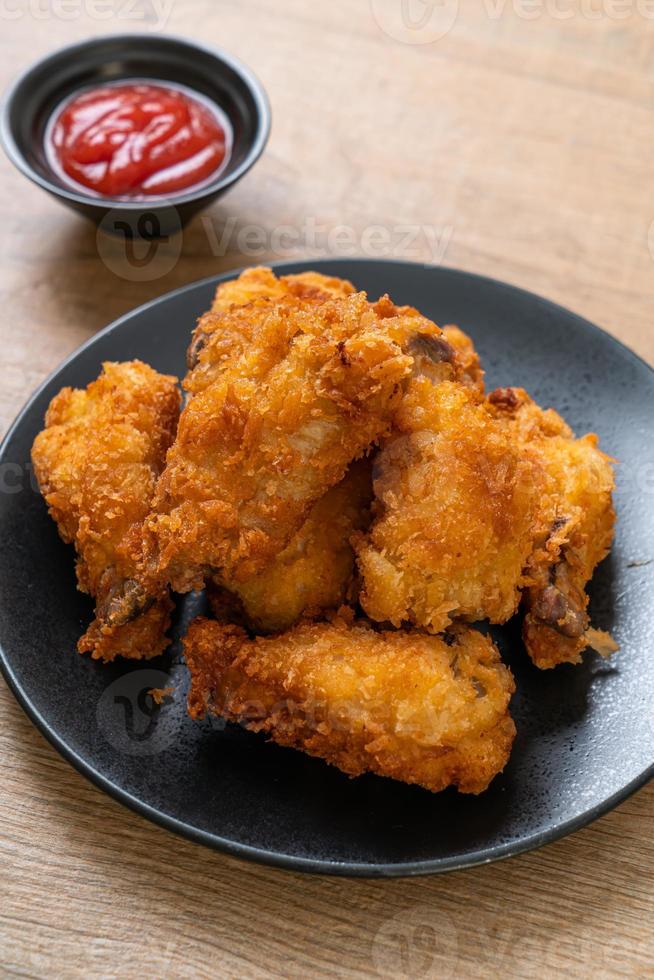 asas de frango frito com ketchup - comida não saudável foto