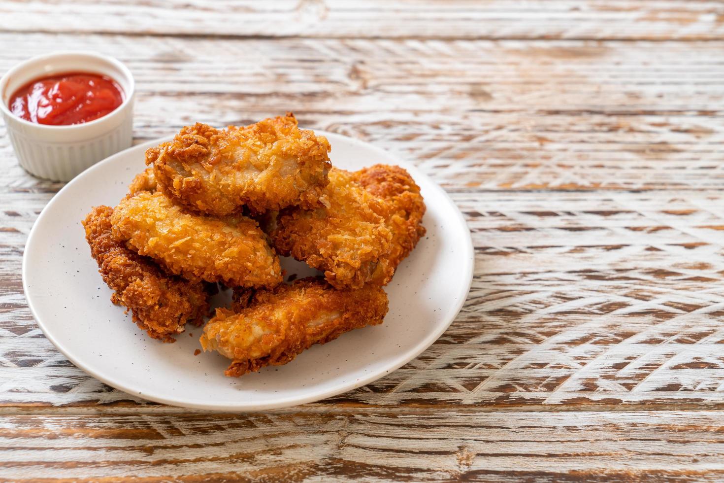 asas de frango frito com ketchup - comida não saudável foto