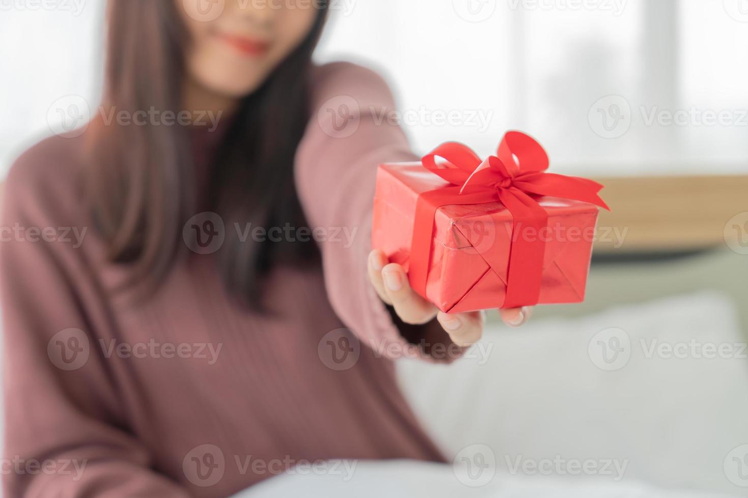mulher asiática feliz em receber uma caixa de presente ou presente foto