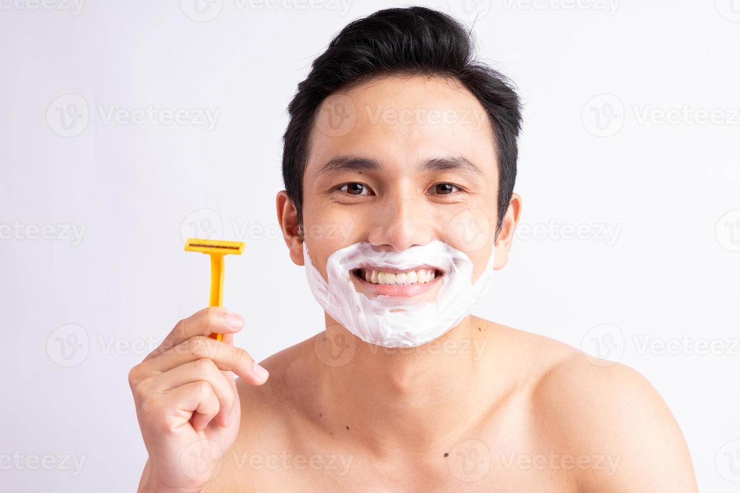 retrato de homem asiático fazendo a barba foto