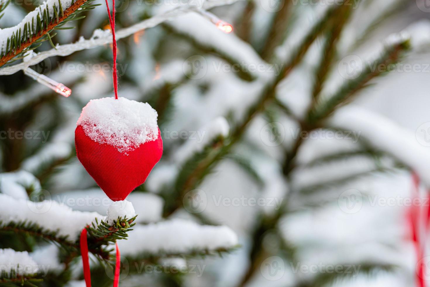 decorações coloridas em galhos de árvores de natal cobertas de neve foto