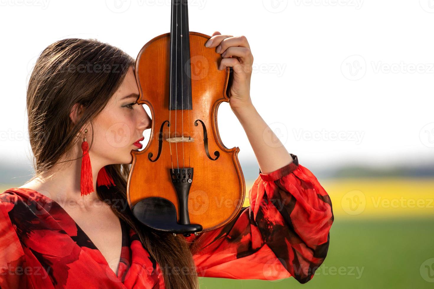 retrato de uma jovem positiva. parte do rosto é coberta pelo pescoço do violino - imagem foto