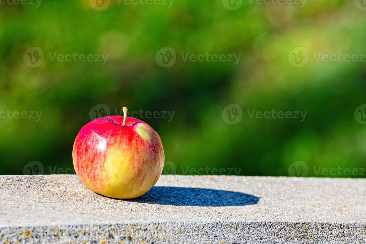 maçã no meio-fio de granito foto