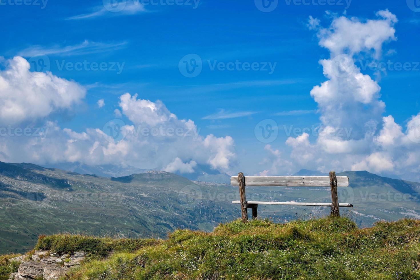 um banco de madeira no topo dos Alpes foto