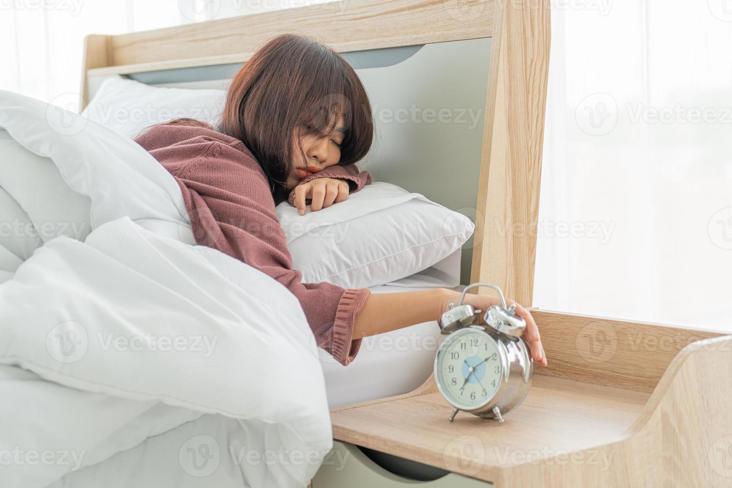 mulher asiática na cama e acordando de manhã foto