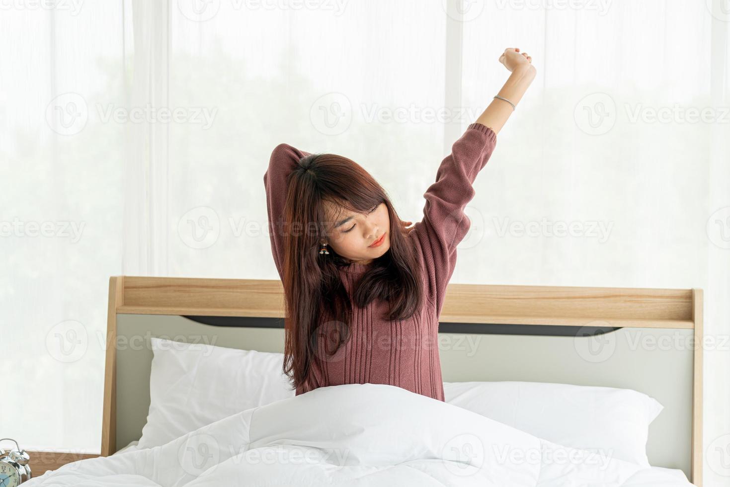 mulher asiática na cama e acordando de manhã foto