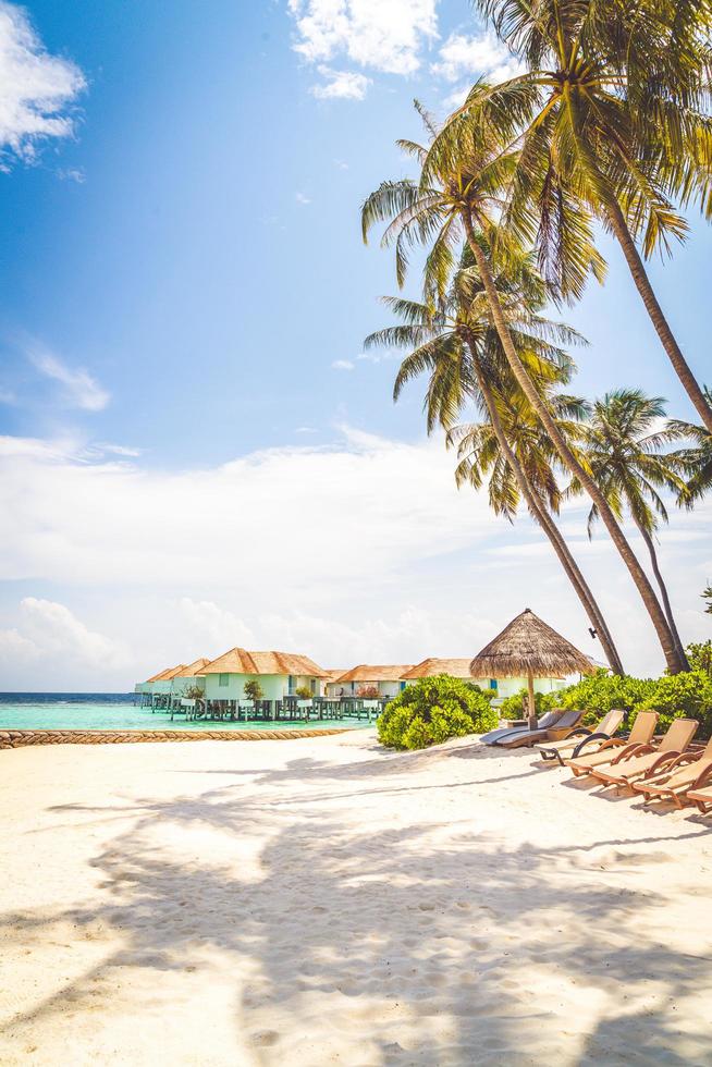 cadeiras de praia com ilha tropical das Maldivas praia e mar - conceito de plano de fundo de férias de férias foto