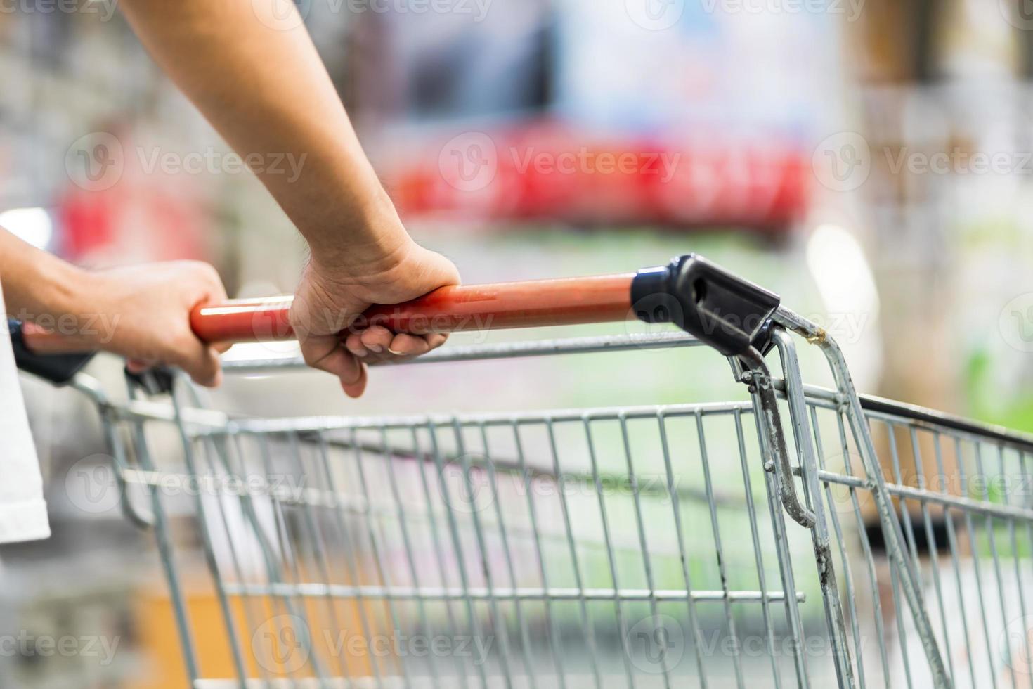 close-up de homem empurrando carrinho de compras em um supermercado foto