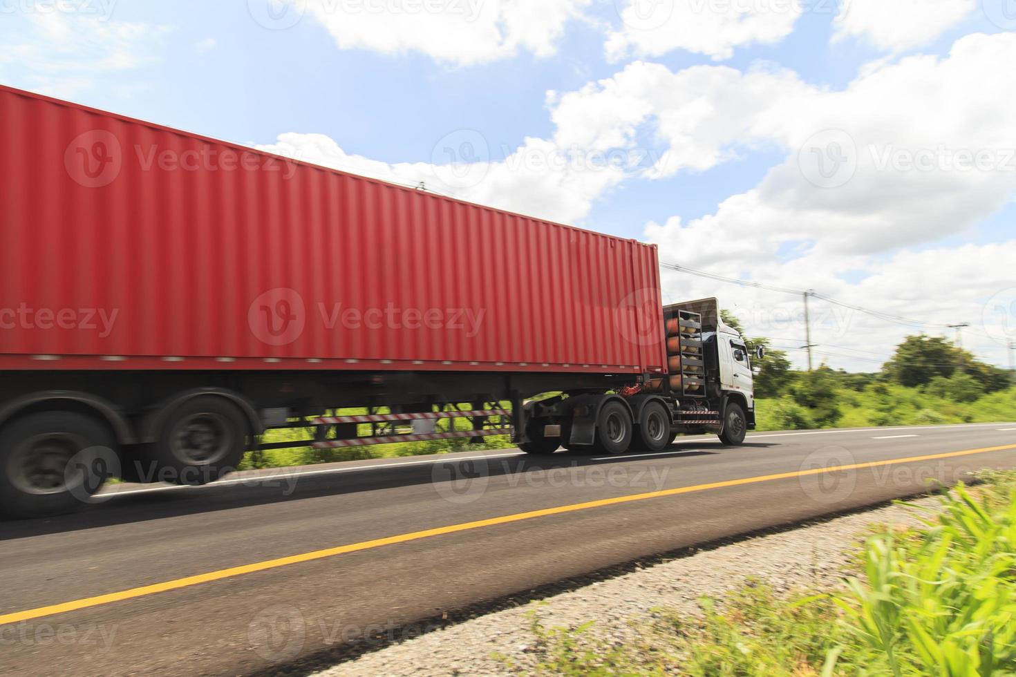 caminhão vermelho na rodovia sob o céu azul foto