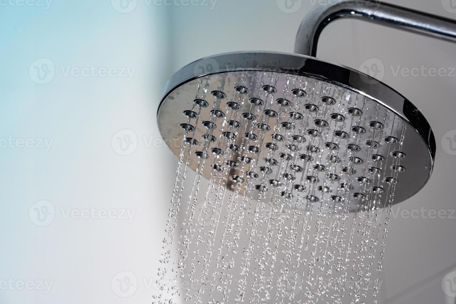 close-up da água fluindo do chuveiro no banheiro foto