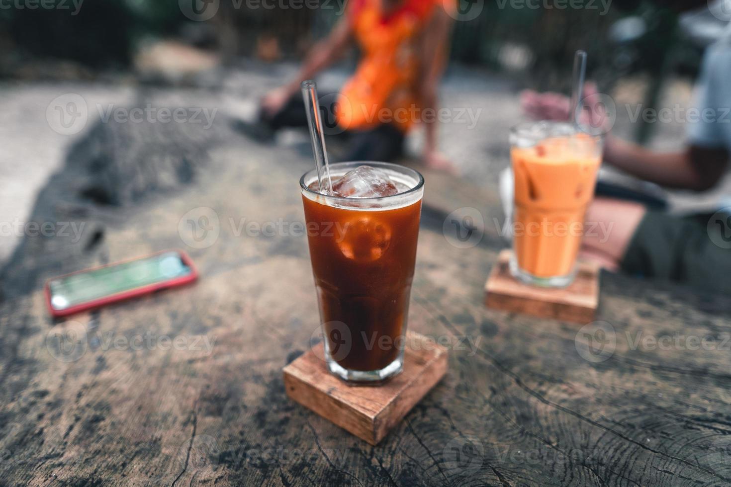 Café gelado em copo sobre mesa de madeira foto