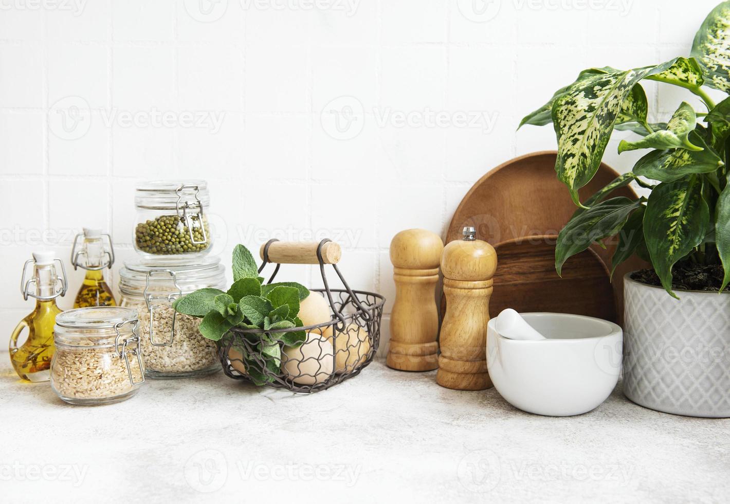 utensílios de cozinha, ferramentas e louças na parede de azulejos brancos de fundo. foto